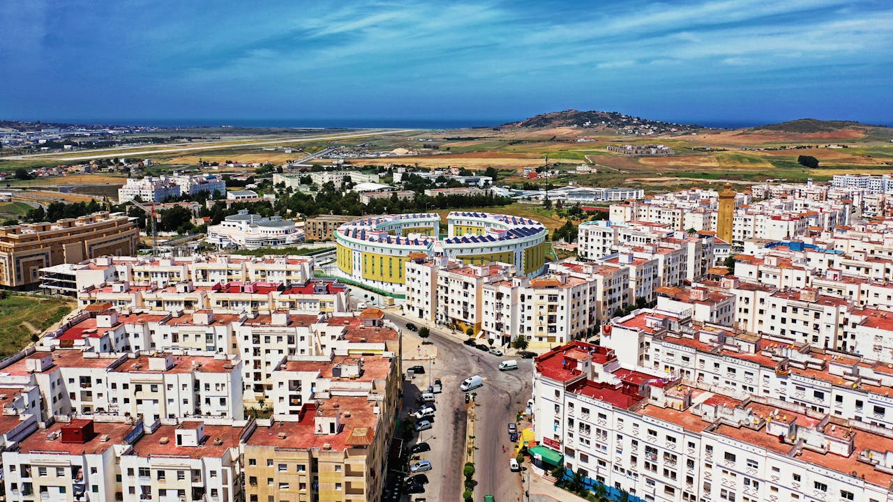 Drone shot of Tanger cityscape, residential buildings, and coastal view in Morocco.