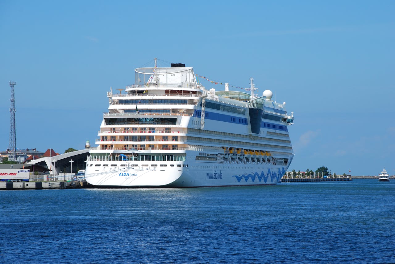 A luxury cruise ship moored at a dock, showcasing its grandeur against a clear blue sky.